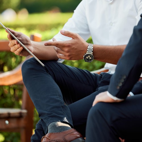 two business people talking on a bench
