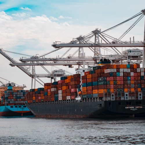 docked cargo ships unloading shipping containers